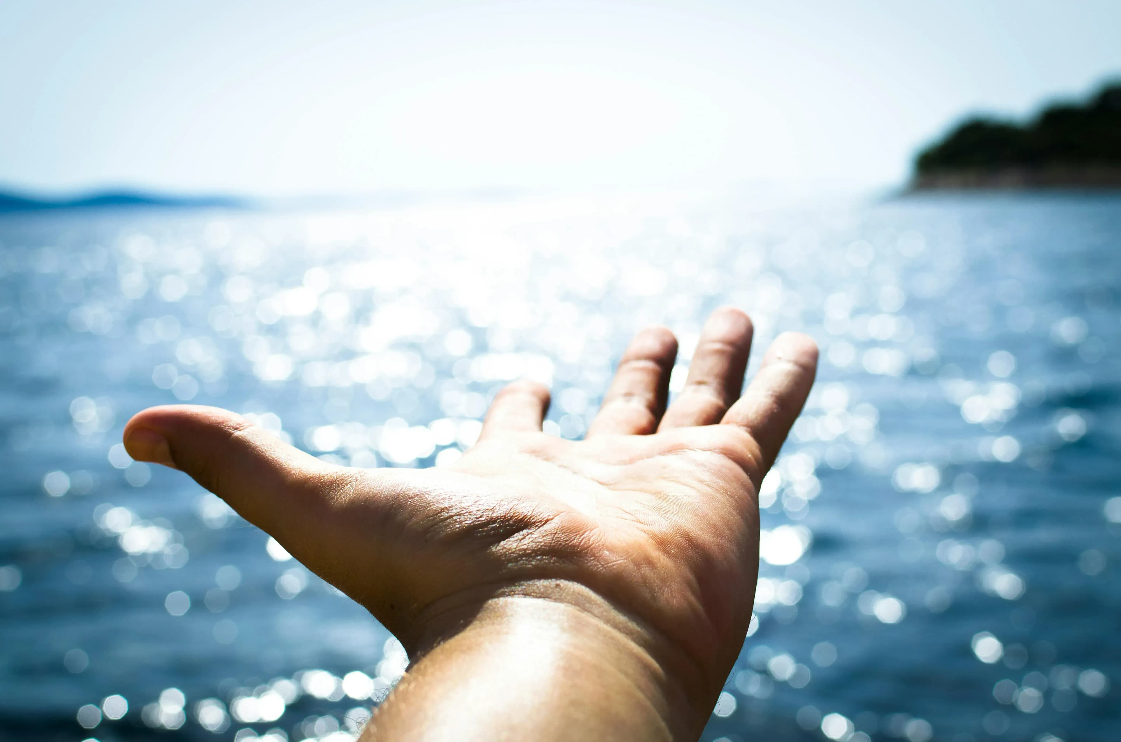 Ausgestreckte Hand vor Wasser